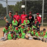 A photo of a youth baseball team celebrating with their championship medals, taken at home plate